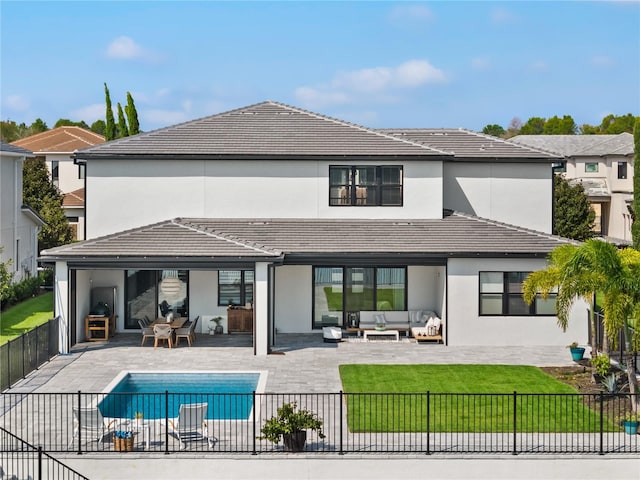 rear view of house featuring a fenced in pool, a patio area, a yard, and an outdoor hangout area