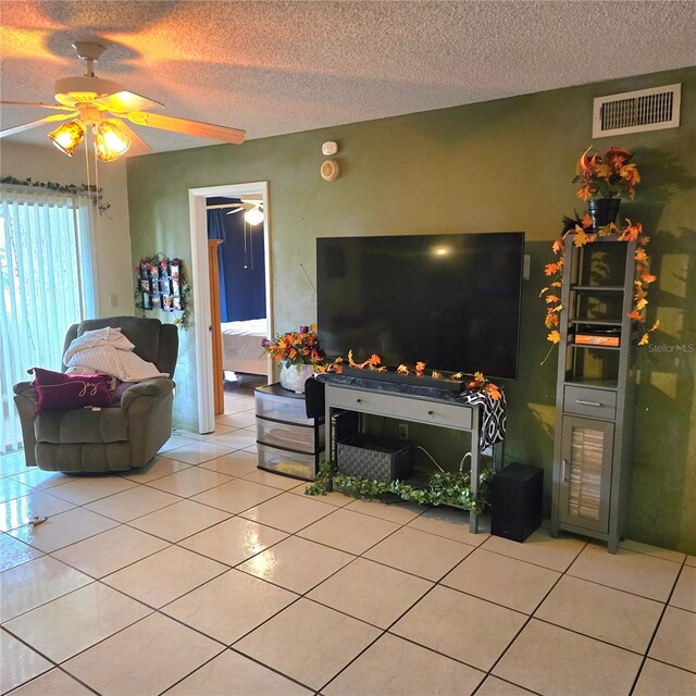 tiled living room with a textured ceiling and ceiling fan