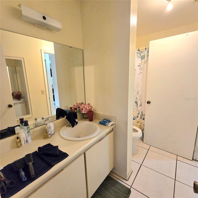 bathroom with tile patterned flooring, vanity, and toilet