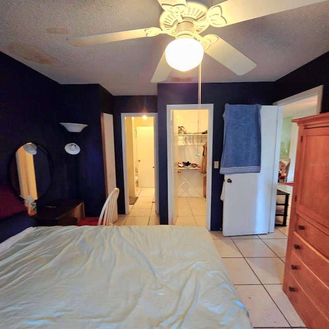 tiled bedroom featuring ceiling fan and a textured ceiling