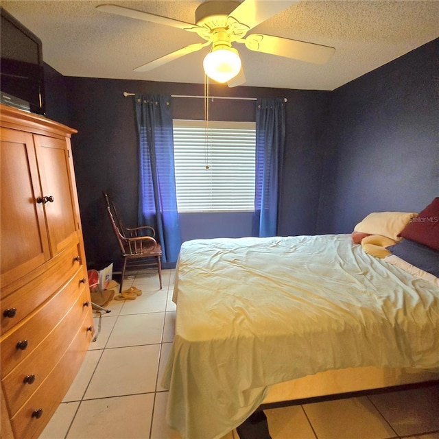 tiled bedroom featuring ceiling fan and a textured ceiling