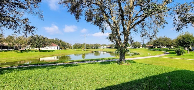 surrounding community featuring a water view and a lawn