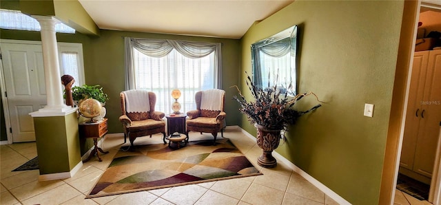 sitting room featuring lofted ceiling, decorative columns, and light tile patterned floors