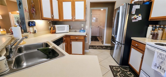 kitchen featuring white appliances, sink, and light tile patterned floors