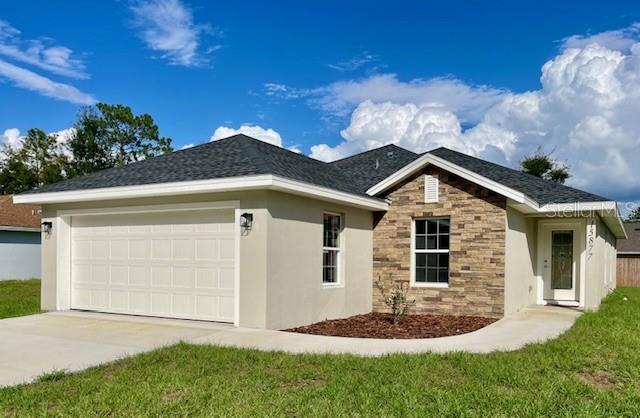 ranch-style home with driveway, stucco siding, a garage, and stone siding