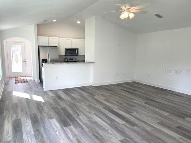 unfurnished living room with ceiling fan, dark wood-type flooring, and vaulted ceiling