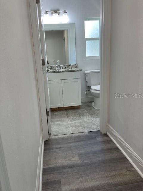 bathroom featuring vanity, toilet, and hardwood / wood-style flooring