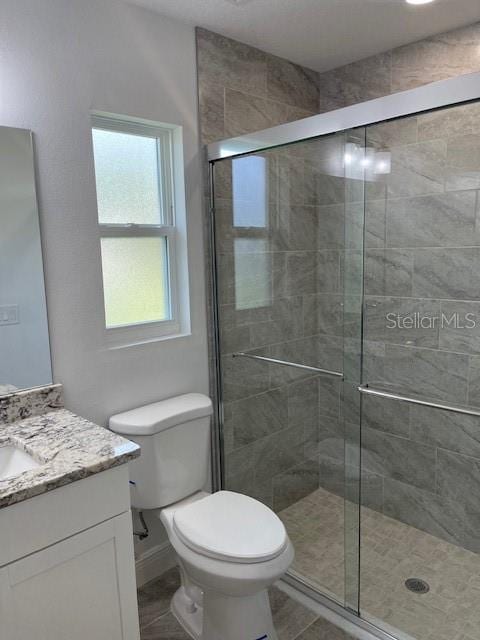 bathroom with vanity, toilet, and an enclosed shower