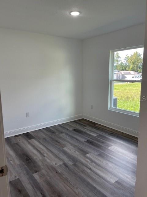 spare room featuring dark wood-type flooring