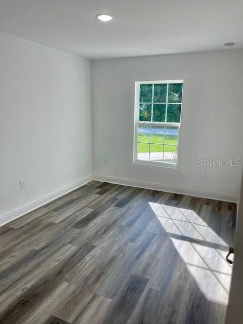 unfurnished room featuring dark wood-type flooring