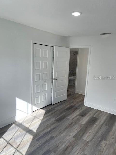 empty room featuring recessed lighting, baseboards, and wood finished floors