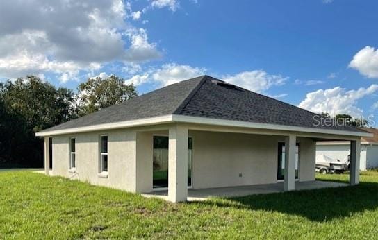 rear view of property featuring a lawn and a patio area