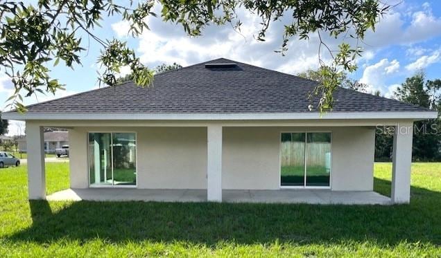 rear view of house featuring a yard