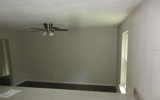 unfurnished room with dark hardwood / wood-style flooring and ceiling fan