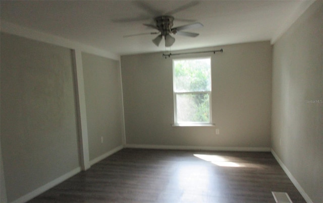 empty room featuring dark hardwood / wood-style flooring and ceiling fan