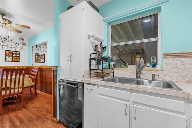 kitchen featuring tasteful backsplash, black dishwasher, white cabinetry, hardwood / wood-style flooring, and sink