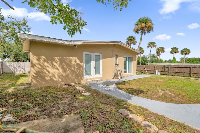 rear view of property featuring a patio, french doors, and a yard