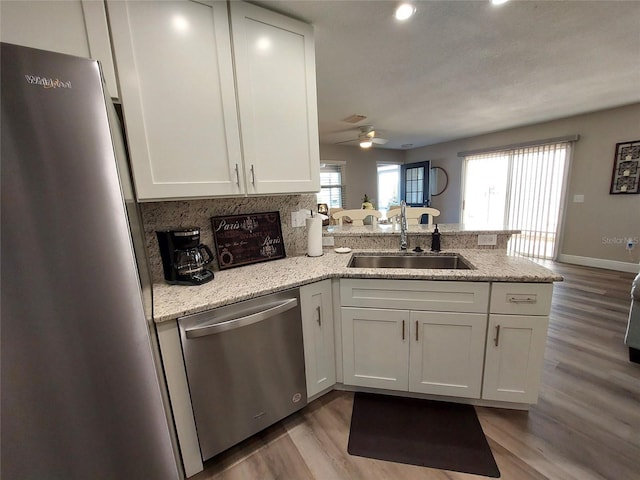 kitchen featuring sink, kitchen peninsula, stainless steel appliances, and a healthy amount of sunlight