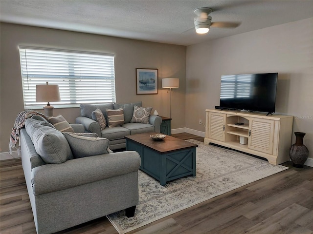 living room featuring a textured ceiling, dark hardwood / wood-style floors, and ceiling fan