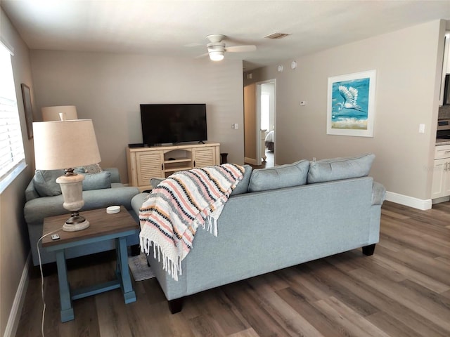 living room with ceiling fan and dark hardwood / wood-style flooring