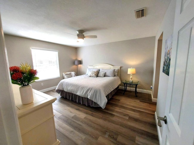 bedroom with dark wood-type flooring and ceiling fan