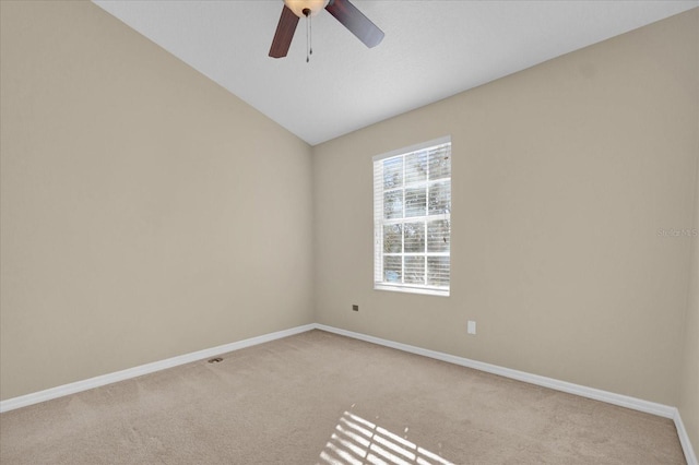 carpeted spare room featuring lofted ceiling and ceiling fan