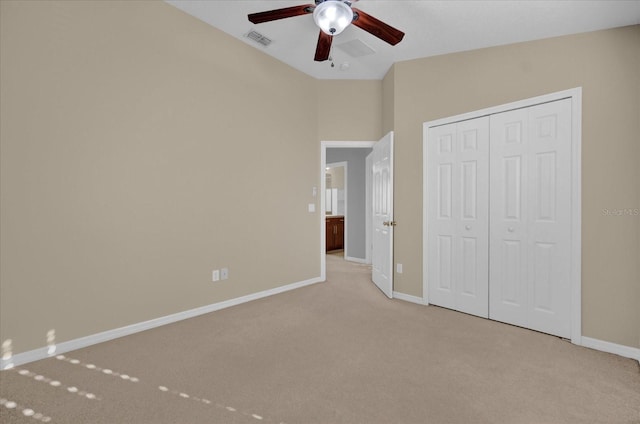 unfurnished bedroom featuring light carpet, a closet, and ceiling fan