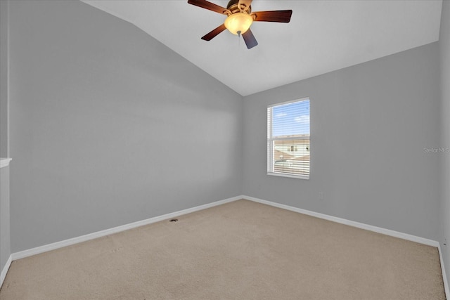 carpeted empty room featuring vaulted ceiling and ceiling fan