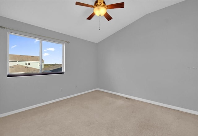 carpeted empty room featuring ceiling fan and vaulted ceiling