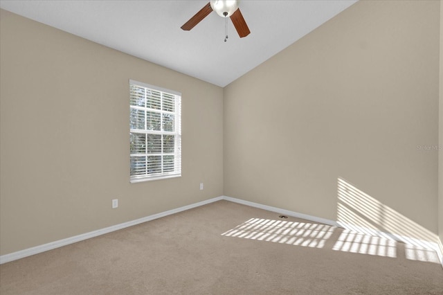 spare room with light carpet, vaulted ceiling, and ceiling fan