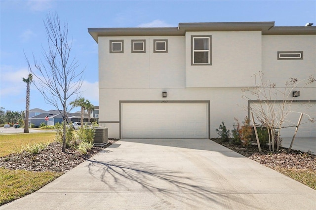 view of front of property featuring a garage and central AC