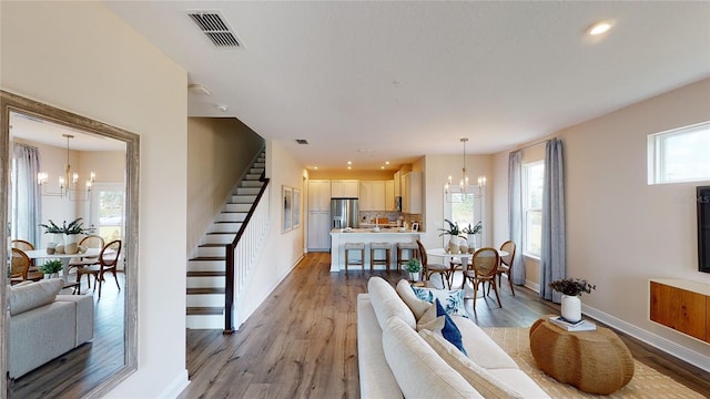 living room featuring light hardwood / wood-style flooring, plenty of natural light, and a notable chandelier