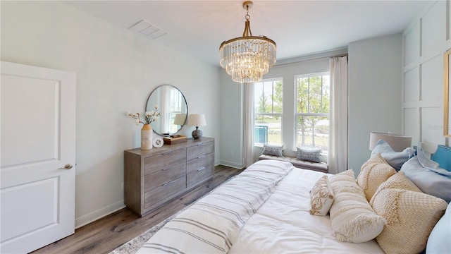 bedroom with wood-type flooring and a chandelier