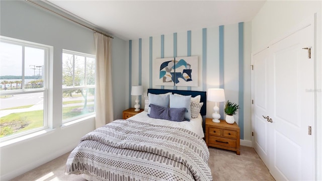 bedroom with multiple windows and light colored carpet