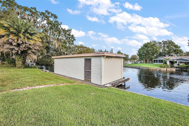 view of outdoor structure featuring a water view and a lawn