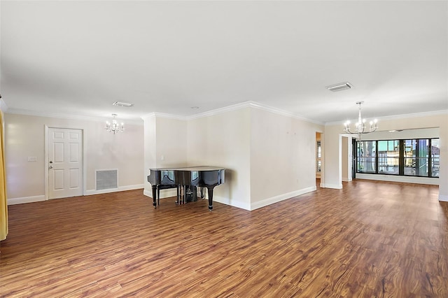 empty room featuring hardwood / wood-style floors, an inviting chandelier, and ornamental molding