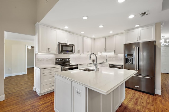 kitchen featuring high end refrigerator, dark wood-type flooring, electric range, and an island with sink