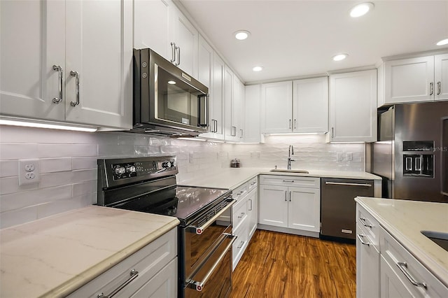 kitchen with dark wood-type flooring, white cabinetry, sink, and stainless steel appliances