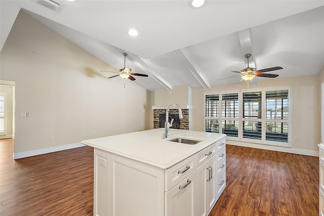 kitchen featuring a kitchen island with sink, dark wood-type flooring, sink, white cabinets, and vaulted ceiling with beams