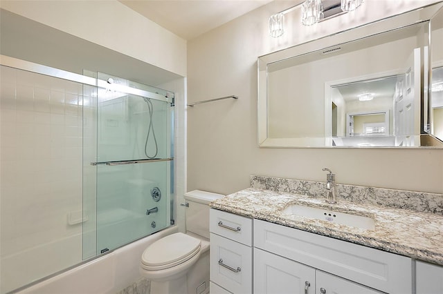 full bathroom featuring toilet, vanity, and combined bath / shower with glass door