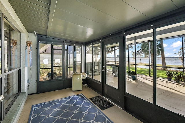 unfurnished sunroom with a healthy amount of sunlight and a water view