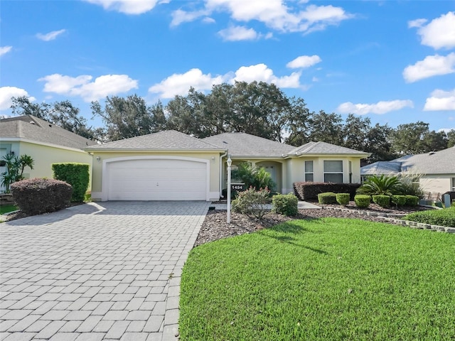 single story home featuring a garage and a front lawn