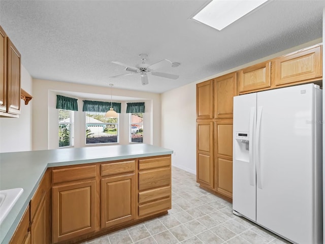 kitchen featuring ceiling fan, pendant lighting, white fridge with ice dispenser, sink, and a textured ceiling