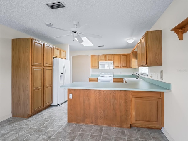 kitchen featuring ceiling fan, sink, kitchen peninsula, white appliances, and a textured ceiling