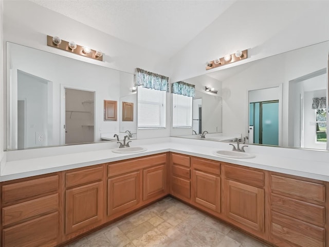 bathroom featuring lofted ceiling, vanity, and a textured ceiling