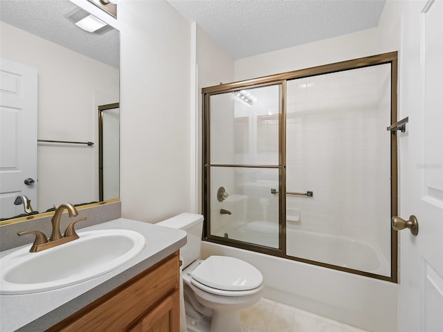 full bathroom with a textured ceiling, bath / shower combo with glass door, vanity, and toilet