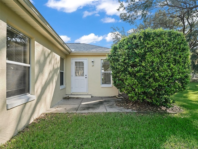 view of exterior entry with a yard