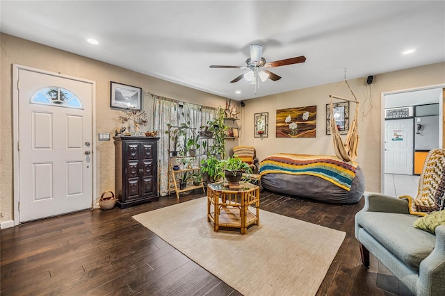 living room with dark wood-type flooring and ceiling fan