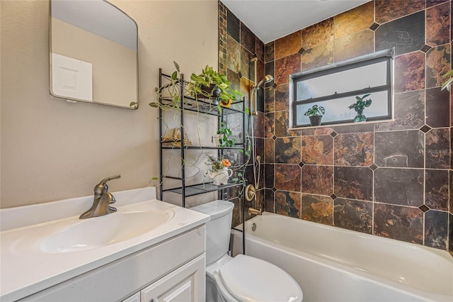 full bathroom featuring tiled shower / bath, vanity, and toilet