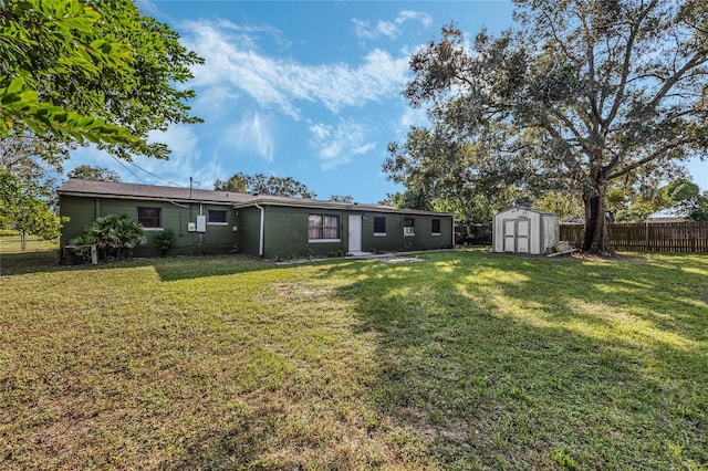 rear view of house with a storage unit and a yard